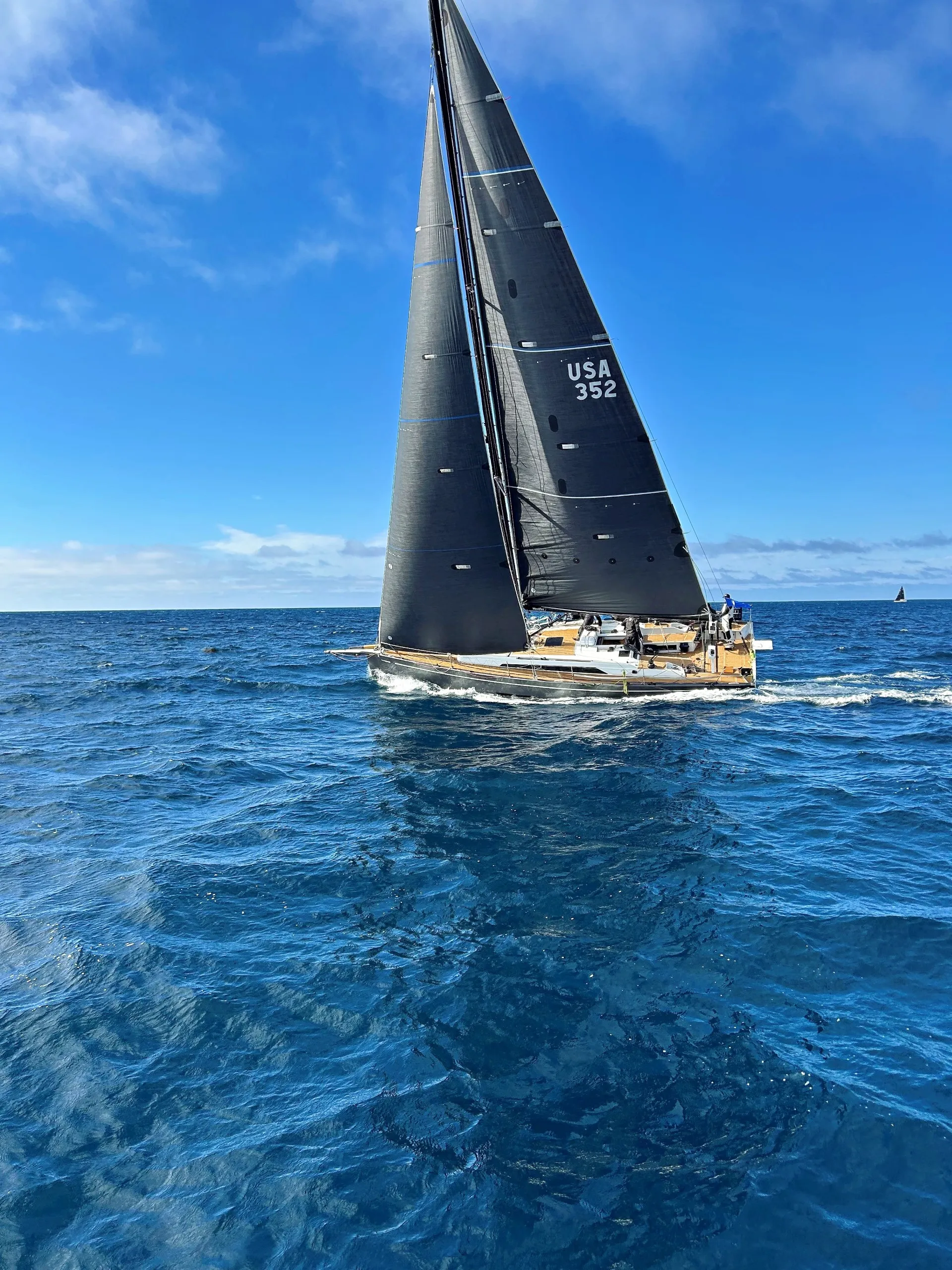 Blackwing racing under full sail on deep blue water